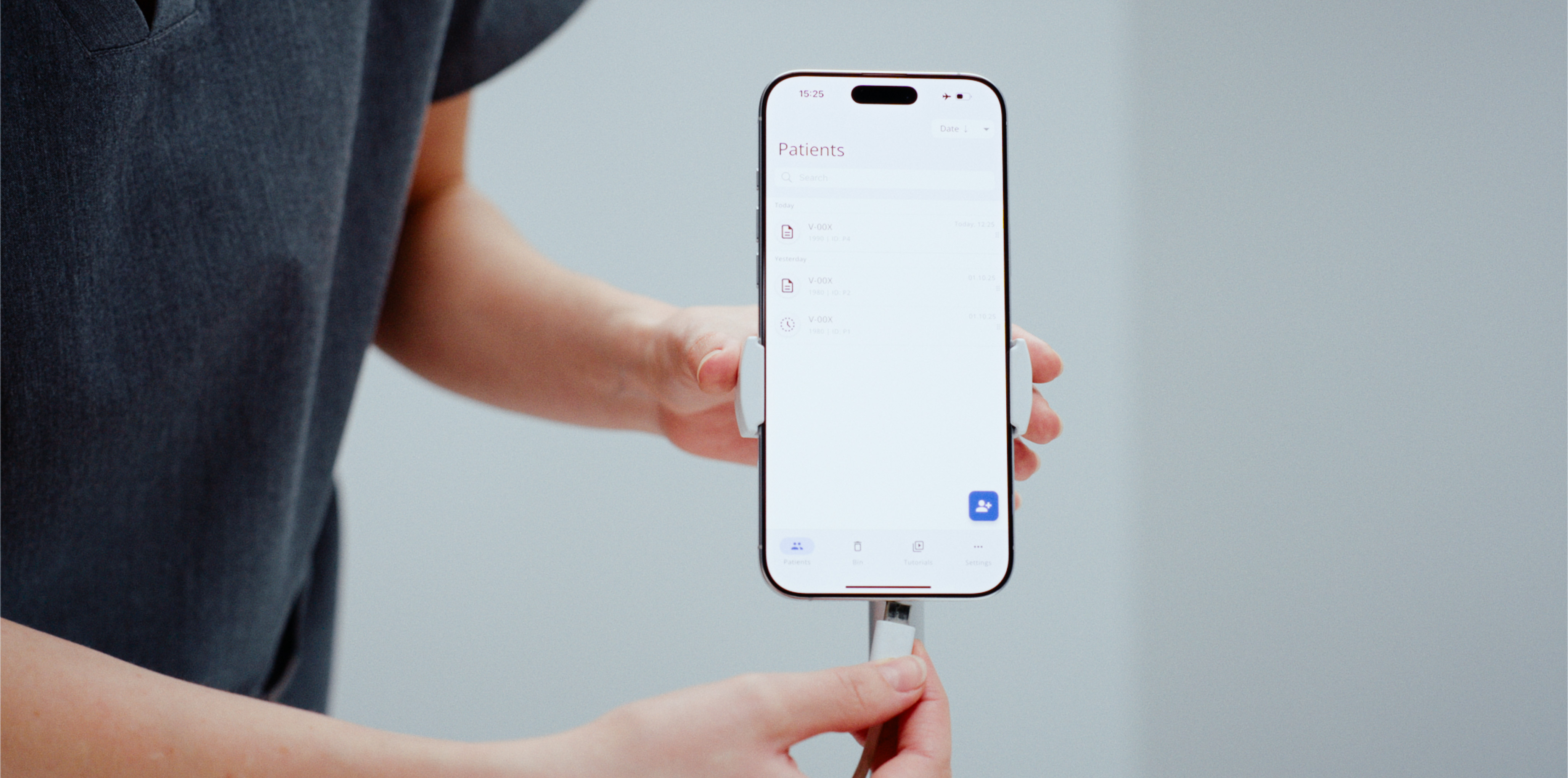 Assistant preparing the VertifyMed app on a smartphone stand